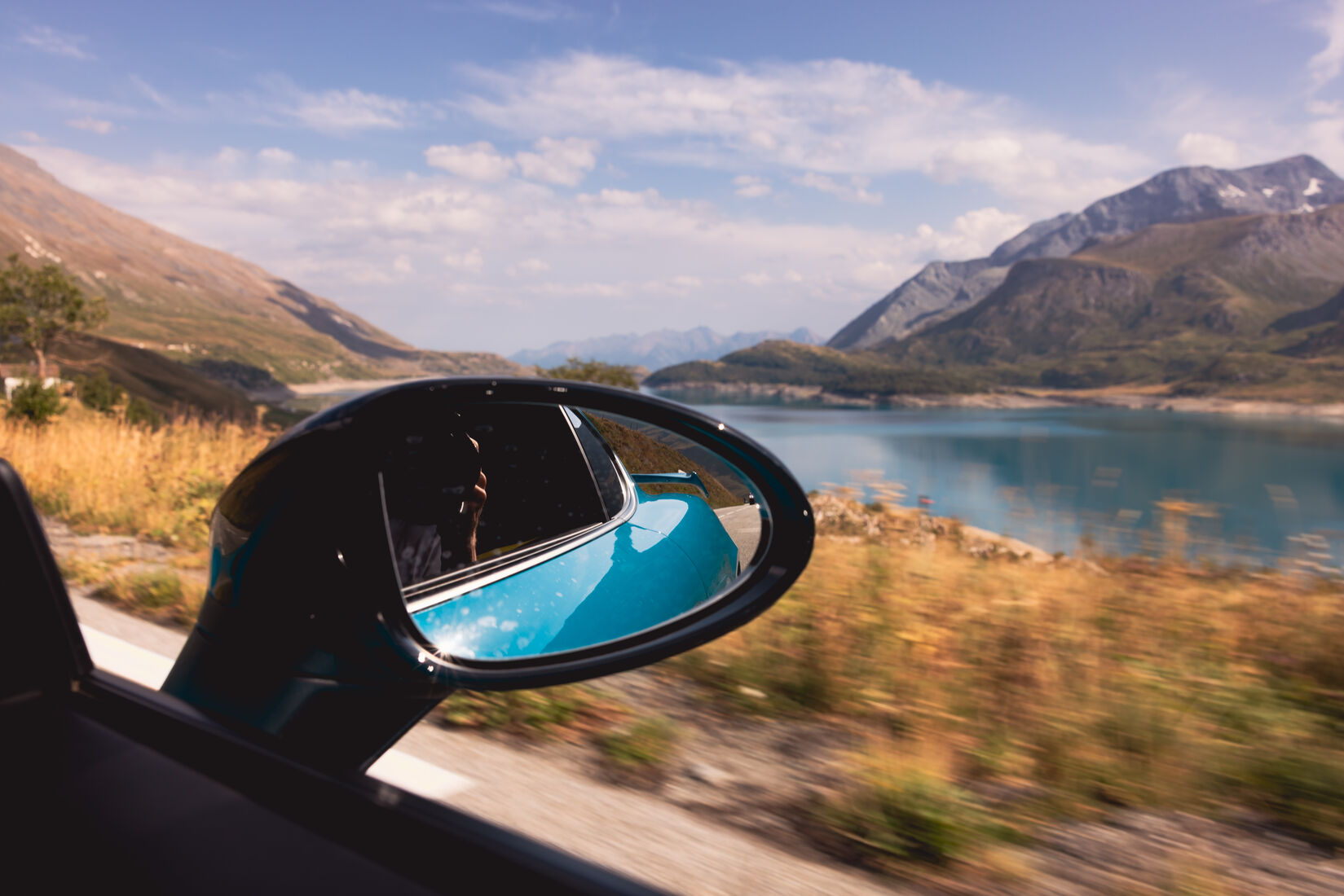 Bergsee im Seitenspiegel während der Fahrt
